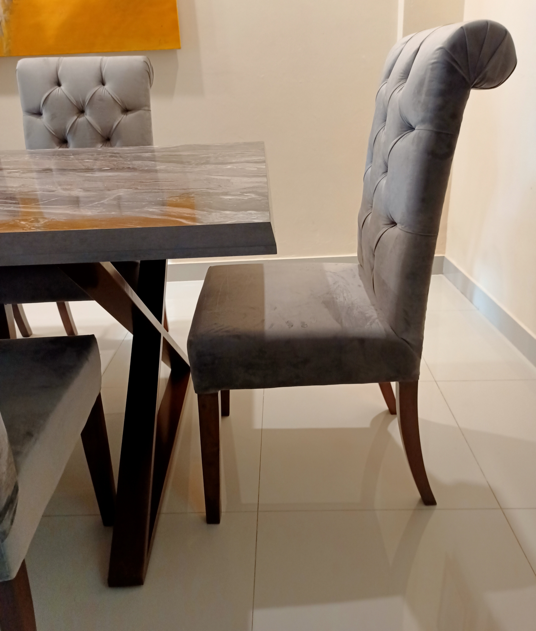 Arzu dining table with 4 upholstered chairs in a modern setting.