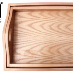 Top view of two wooden trays with curved handles.
