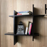 Asymmetric square floating wall shelf with books and decor.
