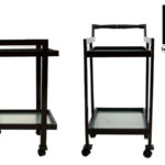 Black wooden tea trolley with glass shelf and wheels, shown from two angles.