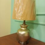 Bards Table Lamp with a golden base and beige lampshade"
