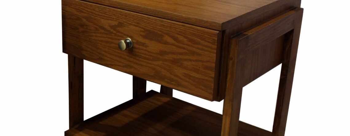 Wooden Mika side table with a drawer and lower shelf in an oak finish.